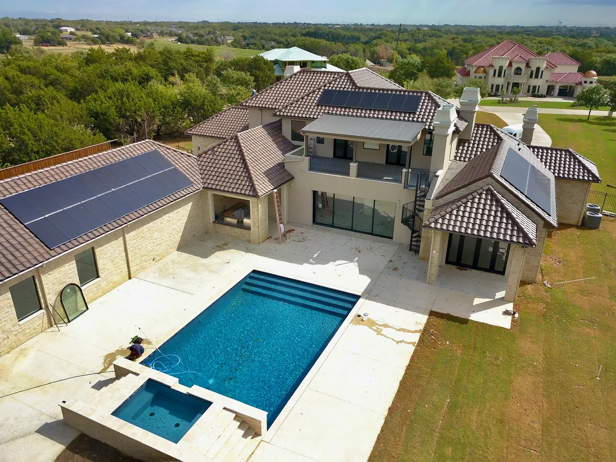 Aerial view of a large DFW home with solar arrays on several roofs