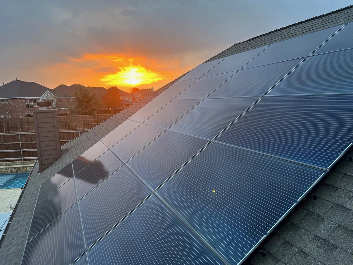 Clean, well-kept solar panels on a DFW roof at sunset