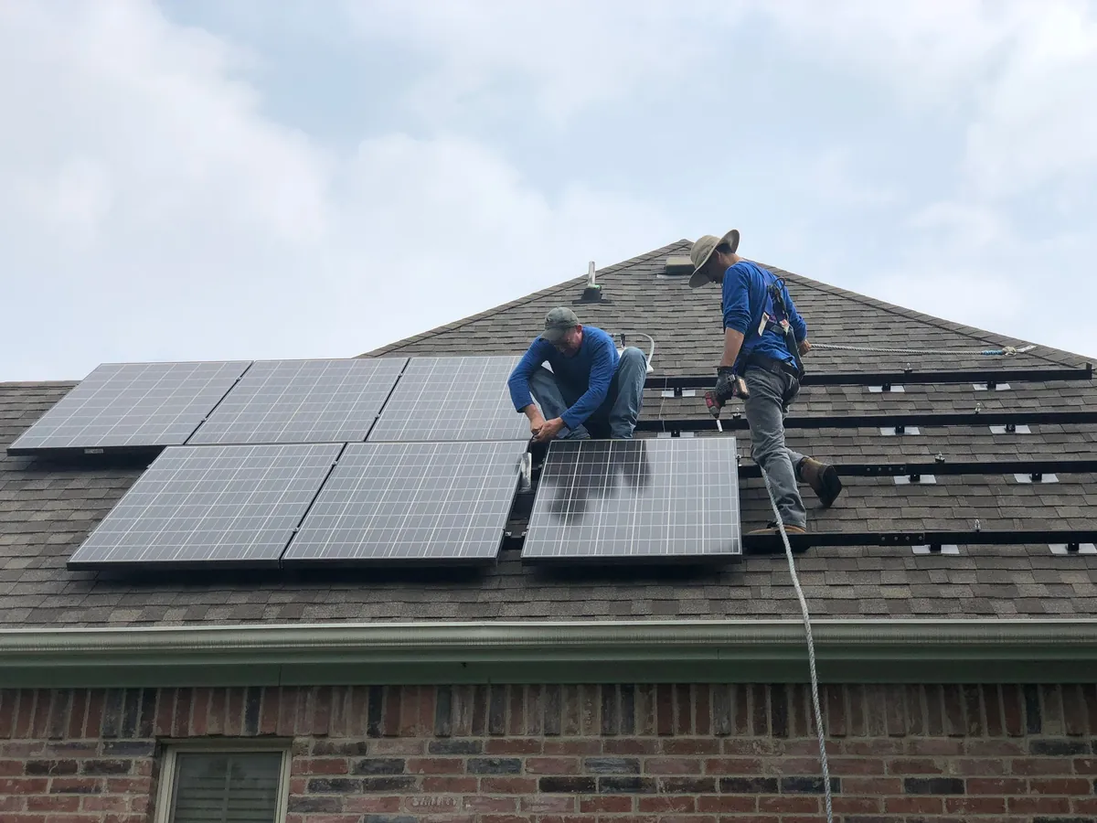 Eagle Solar crew detaching panels from a shingle roof before a re-roof